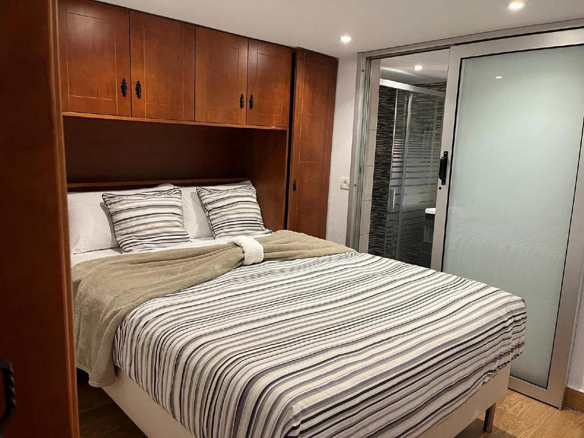 Encantadora: bedroom with a double bed built into a wooden wardrobe unit